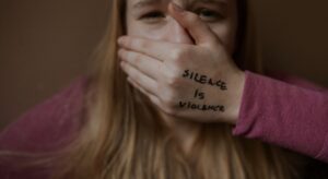 girl with silence is violence on hand
