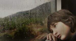 sad kid looking out window